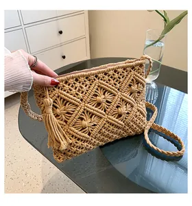 Macro shot of boho macrame weave details, cotton tassels and zipper on the crossbody bag