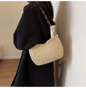 Detalle de bolso hobo tejido con correa de cadena dorada y cuero sintético en modelo
