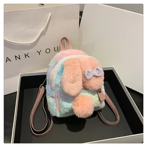 Detail of plush bunny ears with purple bows on a colorful tie-dye mini backpack