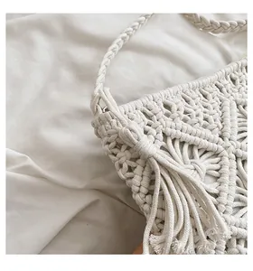Close-up of cream handmade macramé woven bag featuring intricate geometric patterns and tassels