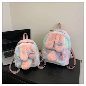 Detail view of rainbow plush bunny backpacks with soft pink ears and fuzzy pompom tails