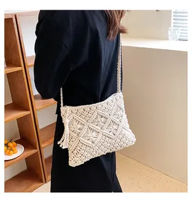 Detail of cream woven bohemian crossbody bag with handmade diamond hollow patterns and tassels