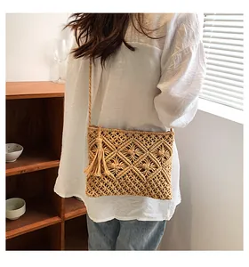 Detail of bohemian woven crossbody bag featuring wheat ear patterns and tassel charm
