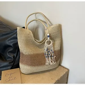 Detail of straw woven tote with evil eye tassel charm on a stone base