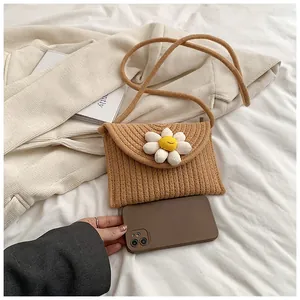 Détail du sac bandoulière en paille tressée avec marguerite 3D et fine bandoulière corde