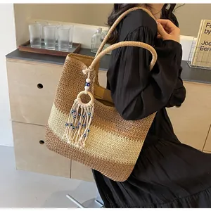 Close-up of bohemian woven tote bag showing tri-color chevron patterns and tassel charm