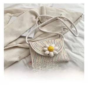 Détail du mini sac bandoulière tissé avec fleur de marguerite et coutures colorées