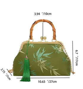 Detail of bamboo handle and emerald silk embroidery on the vintage handbag
