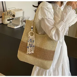 Detail of bohemian straw tote bag with blue evil eye tassel charm and striped texture
