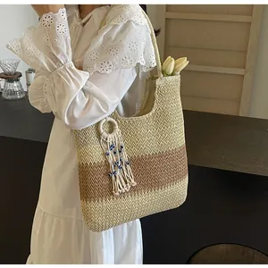 Detail of bohemian three-tone straw tote bag with evil eye charm and tulip decor