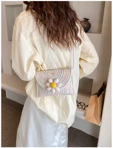 Détail du sac bandoulière tissé avec motifs ondulés colorés et décor de marguerite 3D