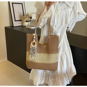 Detail of woven straw tote bag featuring bohemian tassels and beads for summer travel