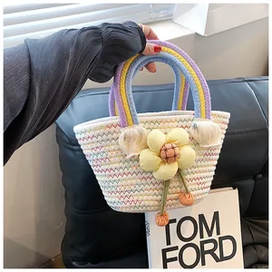 Détail du sac en paille tissé main avec anse arc-en-ciel et pendentif fleur jaune
