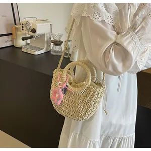 Λεπτομέρεια από ψάθινη τσάντα παραλίας με στρογγυλές λαβές και λουλουδάτο διακοσμητικό