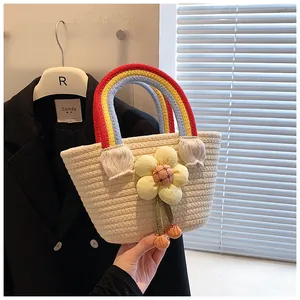 Vue détaillée du sac en paille fait main avec anses arc-en-ciel colorées et décor floral