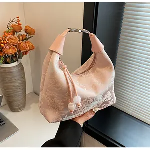 Detailed close-up of pink silk embroidery handbag with traditional Chinese landscape patterns