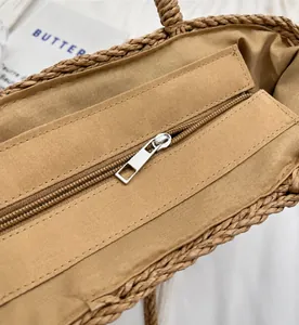 Close-up of smooth silver zipper and fabric lining inside the woven straw beach bag