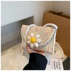 Vue détaillée du sac bandoulière tissé avec motifs à vagues colorés et décor de marguerites