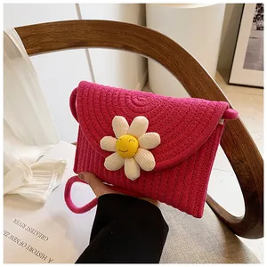 Détail du sac bandoulière tressé rouge rose avec fleur de marguerite et texture