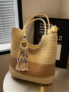 Three-tone woven straw tote bag with evil eye tassel charm for beach vacations