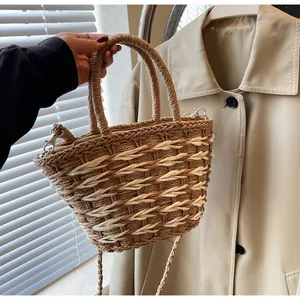 Close-up of woven straw bag detail featuring contrast texture and brown handles