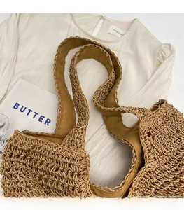 Close-up of brown hollow-out woven straw tote bag with wide shoulder strap