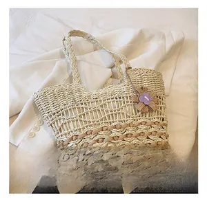 Close-up of beige woven straw tote bag with delicate hollow mesh and purple flower charm