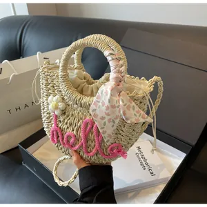 Detailed texture of straw woven bag with pink hello embroidery and floral scarf handle