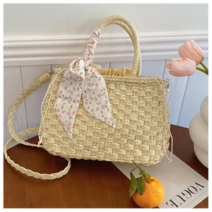 Detalle de bolso de paja con asa de cinta floral y forro interior con cordón