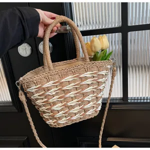Detail of woven straw bucket bag with natural texture, inner fabric lining and shoulder strap