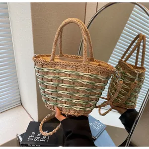Detail of hand-woven straw tote with green stripes and detachable shoulder strap