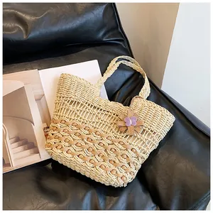 Close-up of hollow diamond texture and woven flower charm on the straw tote bag