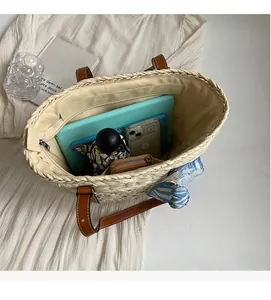 Spacious interior of a woven straw tote bag with leather handles and inner zipper pocket