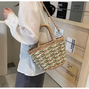 Detail of straw beach bag featuring light green accents and woven shoulder strap