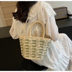 Detailed back view of a straw basket bag with green stripes and detachable shoulder strap
