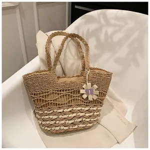 Detailed close-up of a dual-tone woven straw tote bag with a charming daisy flower charm