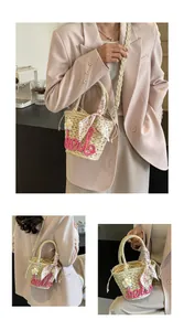 Detail of woven straw bag with pink hello embroidery and floral scarf on handle