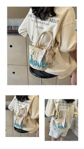 Detailed view of woven straw handbag featuring blue hello embroidery and daisy accents