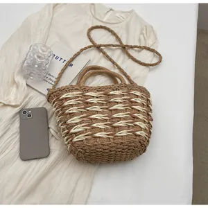 Detail view of woven straw bag with dual handles and shoulder strap for summer beach style