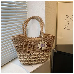 Detail of hand-woven straw tote bag with wave knit patterns and floral pendant charm