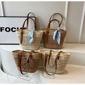 Detail of woven hollow texture on straw bags with leather handles and decorative scarves