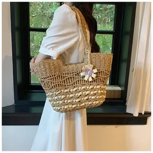 Close-up of woven straw tote bag featuring intricate openwork patterns and flower charm