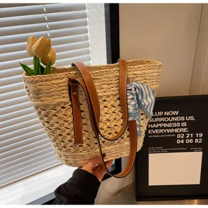 Detailed close-up of woven paper straw tote with brown leather handles and striped silk scarf