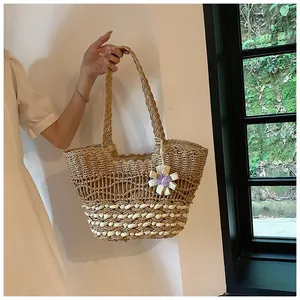 Detail of bohemian straw tote bag with intricate weave and purple crochet flower accent