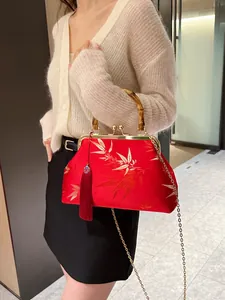 Red Chinese embroidery handbag with bamboo handle and gold leaf patterns on silk