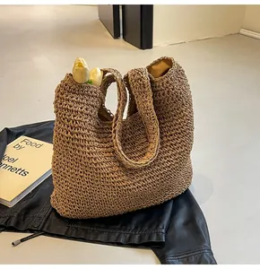 Close-up of brown crochet straw tote bag with mesh texture and floral accents
