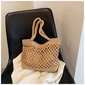 Détail du sac cabas en crochet beige avec motif ajouré et doublure intérieure sur chaise