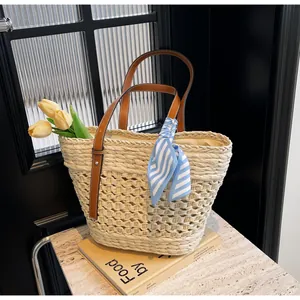 Detail of hand-woven straw tote with leather handles, fabric lining and silk scarf