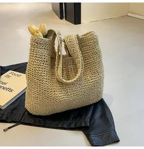 Close-up of beige woven straw tote bag with floral accents and dense artisanal texture
