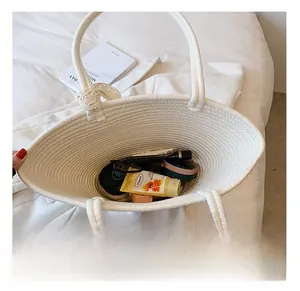 Detail view of large capacity white woven straw bag interior with sunglasses and skincare